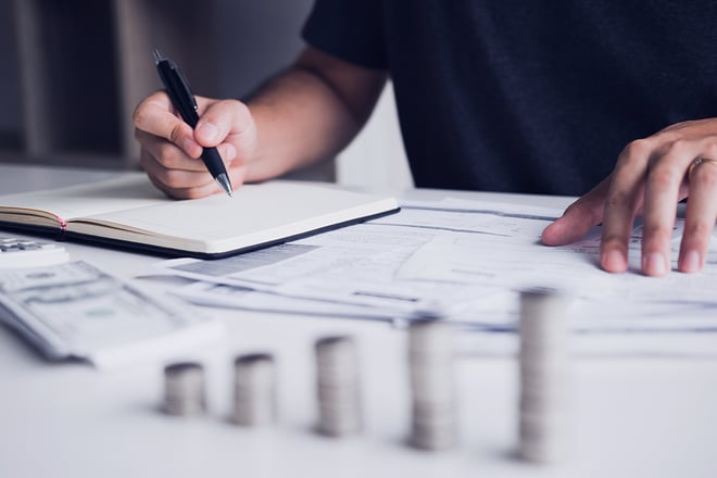 man writing on notepad with pen