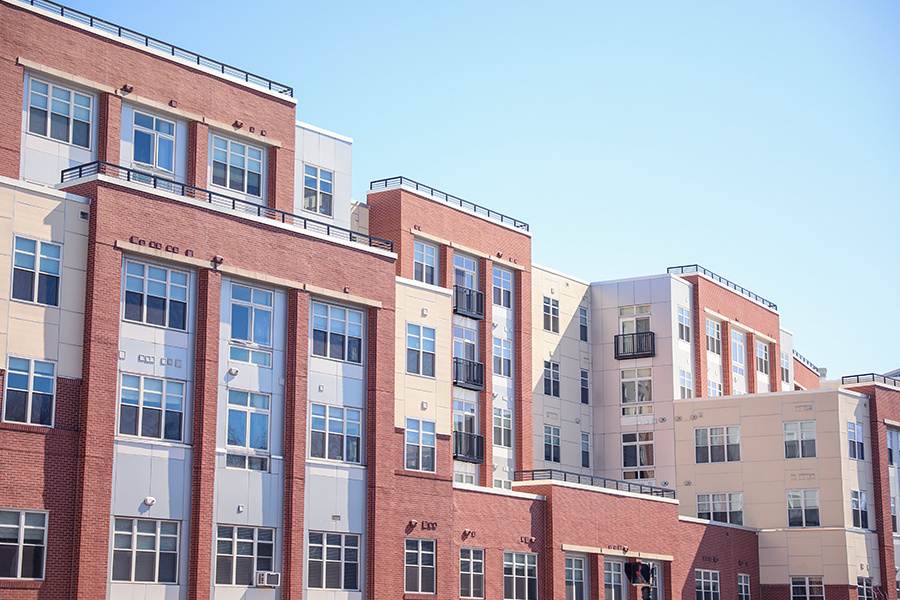 A sleek and modern building exterior with clean lines and large windows that reflect the blue sky